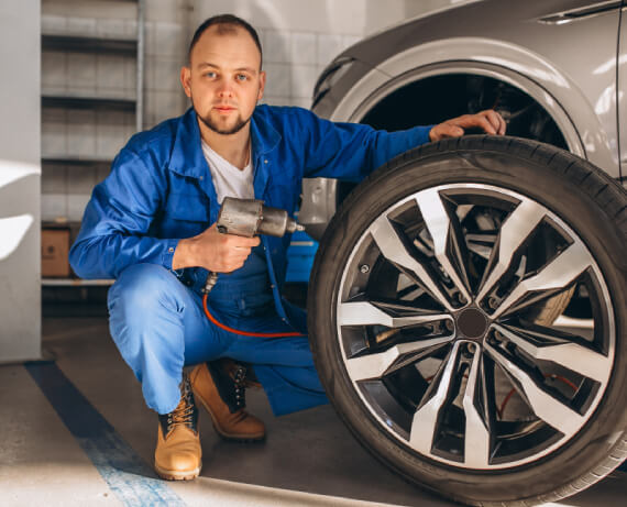 Close-up of a damaged alloy wheel showing scratches, bends, and curb marks for professional repair