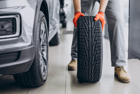 Professional tire repair service inspecting and fixing a damaged car tire at The Tire Studio