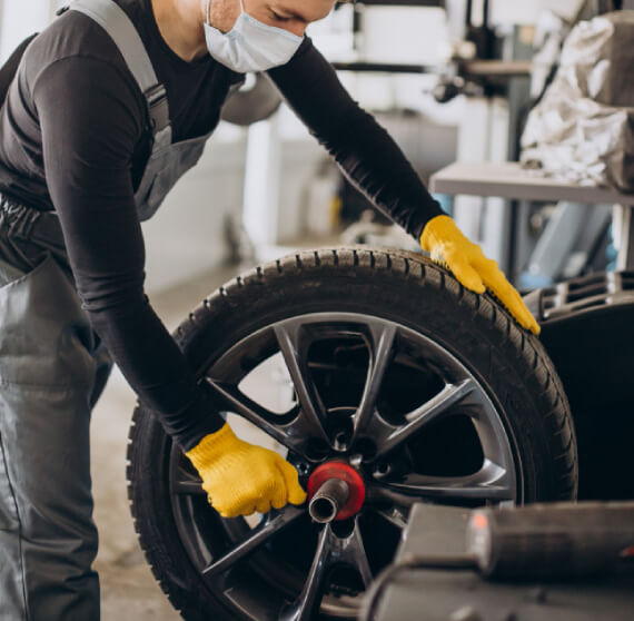 Tire technician performing inspection and repair process on a car tire for safe and reliable driving